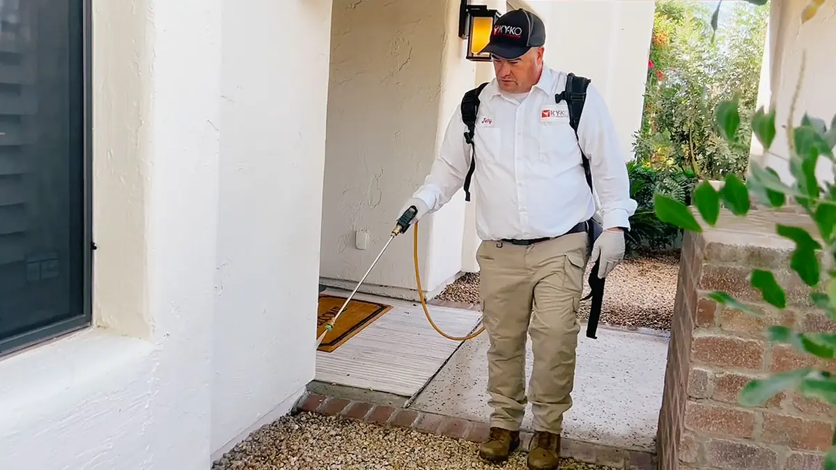 KY-KO technician spraying around a front entry