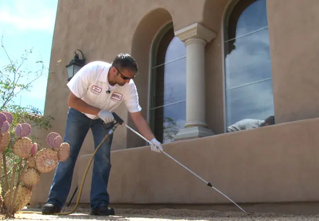 KY-KO technician spraying around a home's perimeter