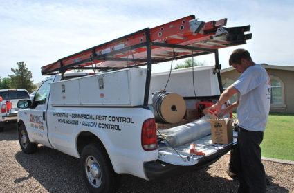 One of our technicians prepares the materials and tools needed for our home sealing pest control service in Phoenix.