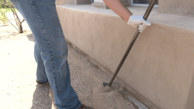 A termite professional builds a trench around a home's foundation as a means of preventing subterranean termites from accessing the slab.